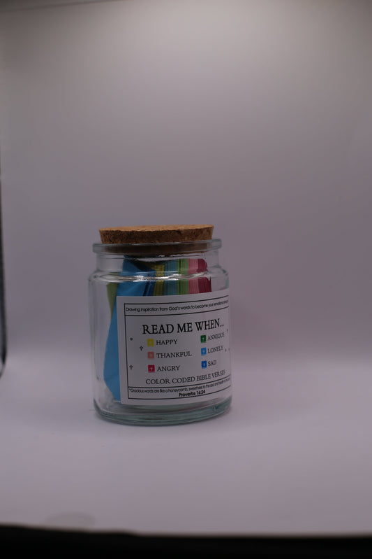 Small glass jar with colorful labels on a white background